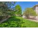 A well-manicured backyard with lush green grass, mature trees and meticulous landscaping creating a serene outdoor oasis at 3480 Spruce Dell Ct, Castle Rock, CO 80109