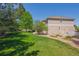 A lush backyard showcasing a well-maintained lawn, mature trees, and meticulous landscaping, offering a serene outdoor setting at 3480 Spruce Dell Ct, Castle Rock, CO 80109