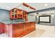 Basement bar features wood cabinets, granite countertops, wine rack, and movie screen beyond at 3480 Spruce Dell Ct, Castle Rock, CO 80109