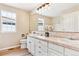 Bright bathroom features double sinks, white cabinets, wood-look floors and a decorative mirror at 3480 Spruce Dell Ct, Castle Rock, CO 80109