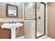 Cozy bathroom featuring a pedestal sink, decorative mirror, and a tiled shower enclosure with glass door at 3480 Spruce Dell Ct, Castle Rock, CO 80109