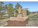 Entrance to The Grange at the Meadows featuring a stone sign and lush landscaping at 3480 Spruce Dell Ct, Castle Rock, CO 80109