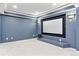 Basement theater room with large screen, wall sconces, and neutral carpet at 3480 Spruce Dell Ct, Castle Rock, CO 80109