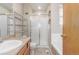 Well-lit bathroom featuring a glass-enclosed shower, soaking tub and functional shelving at 5733 Whitechapel St, Castle Rock, CO 80104