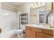 Bathroom with vanity, bath tub, white tile and black metal shelving at 5733 Whitechapel St, Castle Rock, CO 80104