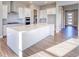 Modern kitchen with island, white cabinets, and stainless steel appliances at 8871 S Quemoy St, Aurora, CO 80016