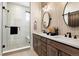 Contemporary bathroom featuring double sinks, modern fixtures, and a glass-enclosed shower with a built-in bench at 888 S Valentia St # 101, Denver, CO 80247