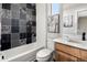 Modern bathroom with decorative tile accent wall, tub, vanity and coordinated wall decor at 888 S Valentia St # 101, Denver, CO 80247
