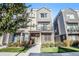 Attractive townhouse features a yellow front door, a small balcony and manicured landscaping at 888 S Valentia St # 101, Denver, CO 80247