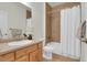 Bathroom with a shower and tub combination with tile surround, single sink, and neutral color palette at 5887 S Taft Ln, Littleton, CO 80127