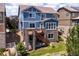 Spacious backyard featuring a stone patio, upper deck, lush greenery, and a privacy fence at 3216 Yale Dr, Broomfield, CO 80023