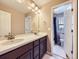 Well-lit bathroom featuring dual sinks, a spacious vanity, and an adjacent toilet room at 3216 Yale Dr, Broomfield, CO 80023