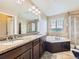 Primary bathroom with dual sinks, granite countertops, and a separate shower and soaking tub at 3216 Yale Dr, Broomfield, CO 80023