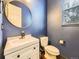 Stylish powder room featuring a modern vanity and a sleek, round mirror for an updated look at 3216 Yale Dr, Broomfield, CO 80023