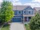 Charming blue two-story home with a well-manicured front yard, covered porch, and attached two-car garage at 3216 Yale Dr, Broomfield, CO 80023
