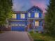 Charming two-story blue home with stone accents, red door and well-maintained landscaping and attached two car garage at 3216 Yale Dr, Broomfield, CO 80023