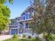 Charming two-story blue home with stone accents, red door and well-maintained landscaping and attached two car garage at 3216 Yale Dr, Broomfield, CO 80023