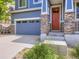 Home featuring a two-car garage, red front door, and stone pillar accents with a cozy front porch at 3216 Yale Dr, Broomfield, CO 80023