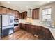 Modern kitchen with stainless steel appliances, granite countertops, dark wood cabinetry, and hardwood floors at 3216 Yale Dr, Broomfield, CO 80023