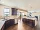 Open concept kitchen with a granite island, stainless steel appliances, dark wood cabinets, and hardwood floors at 3216 Yale Dr, Broomfield, CO 80023
