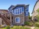 Back of home showcasing stonework, backyard and elevated patio with stairs to ground level at 3216 Yale Dr, Broomfield, CO 80023