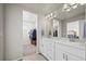 Well-lit bathroom with double vanity, white cabinets, and view to walk-in closet at 12205 Race St, Northglenn, CO 80241