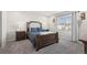 Inviting bedroom with a wooden bed frame, gray carpet, and natural light from the window at 12205 Race St, Northglenn, CO 80241