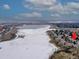 Aerial view of lakeside townhomes near a frozen lake with city and mountain views at 8312 S Peninsula Dr, Littleton, CO 80120