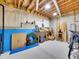 Unfinished basement with exposed ceiling rafters, concrete walls, and storage or workshop area at 8312 S Peninsula Dr, Littleton, CO 80120