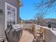 Enjoy this home's covered outdoor deck with wooden chairs and room for entertaining with a grill at 8312 S Peninsula Dr, Littleton, CO 80120