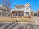 Gray two-story home with a front yard, balcony, bay window, and stone accents at 8312 S Peninsula Dr, Littleton, CO 80120