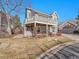 Two-story home in gray with a balcony, set on a small lawn with mature trees at 8312 S Peninsula Dr, Littleton, CO 80120