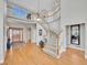 Grand foyer with hardwood floors, a curved staircase, and a view of the second-story balcony at 8312 S Peninsula Dr, Littleton, CO 80120