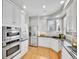 Modern kitchen featuring stainless steel appliances, white cabinets, and hardwood floors. Perfect space to cook in! at 8312 S Peninsula Dr, Littleton, CO 80120