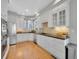 Bright kitchen boasts stainless appliances, white cabinetry and gleaming hardwood floors at 8312 S Peninsula Dr, Littleton, CO 80120