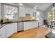 Bright eat in kitchen boasts stainless appliances, white cabinetry and gleaming hardwood floors at 8312 S Peninsula Dr, Littleton, CO 80120