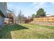 Spacious backyard with green grass, wooden fence, and a small bricked patio area at 11225 W 102Nd Pl, Westminster, CO 80021