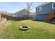 Large backyard with well-kept grass, wooden fence, and a circular fire pit feature at 11225 W 102Nd Pl, Westminster, CO 80021