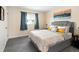 Bedroom with neutral walls, large bed, bedside tables, and a window with blue curtains at 11225 W 102Nd Pl, Westminster, CO 80021