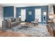 Bright living room featuring a gray sofa, accent chair, modern decor, and a stylish rug on light hardwood floors at 11225 W 102Nd Pl, Westminster, CO 80021