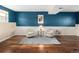 Stylish seating area with hardwood floors, a blue accent wall, and neutral-toned furniture at 11225 W 102Nd Pl, Westminster, CO 80021