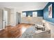 Hardwood-floored living area with blue accent wall, plush rug, and modern decor at 11225 W 102Nd Pl, Westminster, CO 80021