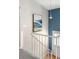 Bright stairwell features white railing, modern light fixture, and mountain-themed artwork accenting the blue-painted wall at 11225 W 102Nd Pl, Westminster, CO 80021