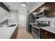 Efficient kitchen design with modern stainless steel appliances and a breakfast bar at 4899 S Dudley St # 19, Littleton, CO 80123