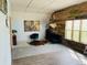 An open concept living room features a wood accent wall and large windows for natural light at 45523 Sun Country Dr, Elizabeth, CO 80107