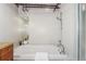 Bathroom features a soaking tub with white tile and a silver shower head with wood cabinets at 1616 14Th St # 4E, Denver, CO 80202