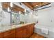 Well-lit bathroom with double sinks and a soaking tub at 1616 14Th St # 4E, Denver, CO 80202