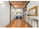 Hallway with hardwood floors, exposed ductwork, seating, and a gold-framed mirror above a glass table at 1616 14Th St # 4E, Denver, CO 80202