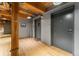 Hallway with exposed wood beams, grey doors, and hardwood flooring at 1616 14Th St # 4E, Denver, CO 80202