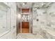 Modern tiled shower with a built in seat and adjacent vanity area visible through the glass door at 1616 14Th St # 4E, Denver, CO 80202